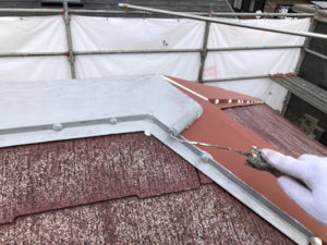 屋根棟板金に錆止めを塗布しています。