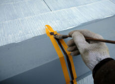 屋根板金のシーリング工事をしています。