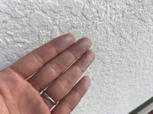 外壁です。指で触ってみると塗料の粉がつきました。これは劣化のサイン（チョーキング現象）です。