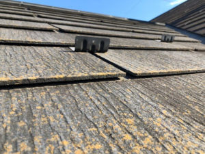 屋根材に軽度の反りが発生しています。吸水を続けた建材が湿潤乾燥の繰り返しで変形をしている状態です。