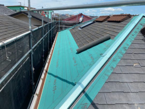 既存屋根に防水シートを取り付け、新しい屋根材を被せていきます。