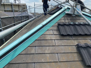 屋根はカバー工法（重ね葺き）です。既存屋根に防水シートを敷き、その上から新しい外壁材を設置していきます