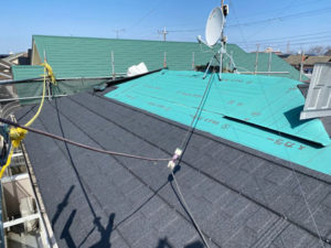 屋根カバー工法。既存の屋根の上に防水シートを敷き、軽量で新しい屋根材を取り付けていきます。