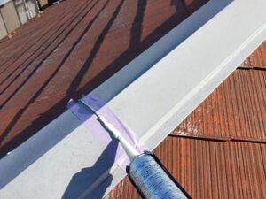 屋根棟板金のシーリング作業。