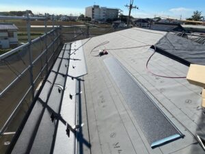 新しい屋根材を張っている様子です。今回は耐久性能の高いSGL鋼板（スーパーガルバリウム鋼板）という素材を使用した屋根材を使っています。